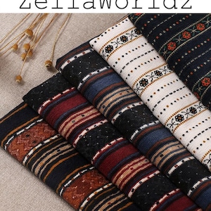 May include: A stack of five fabric swatches with different striped patterns. The swatches are in various colors, including black, white, red, blue, and brown.
