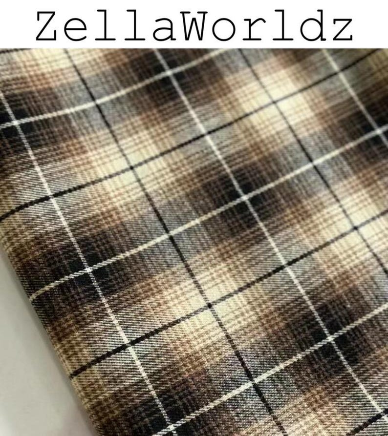 Pu&ograve; includere: Un tessuto con un motivo a quadri marrone, nero e crema con un effetto sfumato. Il testo ZellaWorldz &egrave; stampato in nero nella parte superiore dell'immagine. Il materiale presenta una trama tessuta con linee orizzontali e verticali incrociate.