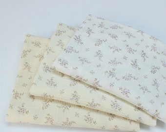 May include: Three pieces of cream-colored fabric with a small floral pattern. The fabric is soft and has a slightly textured surface.