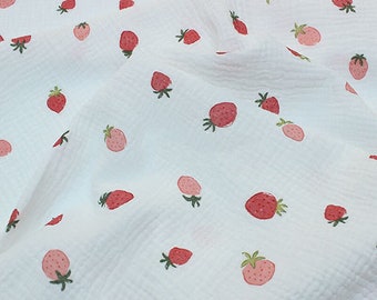 May include: White fabric with a repeating pattern of pink strawberries. The strawberries have green leaves and are scattered randomly across the fabric.