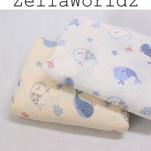 May include: Two pieces of fabric with a whale and starfish pattern. The fabric is white with blue whales and starfish. The fabric is beige with blue whales and starfish.