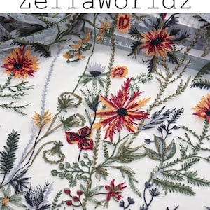 May include: Embroidered fabric with a floral design. The fabric features a variety of colorful flowers in shades of red, orange, yellow, and green, with black and gray accents. The text "ZellaWorldz" is at the top.