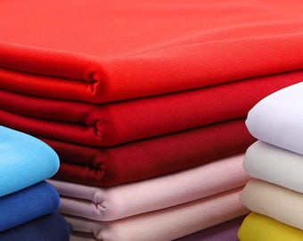 May include: A selection of folded fabric in shades of red, pink, and blue. The image features the text "ZellaWorldz" in black. The fabric appears to be soft and smooth, with a variety of colours.