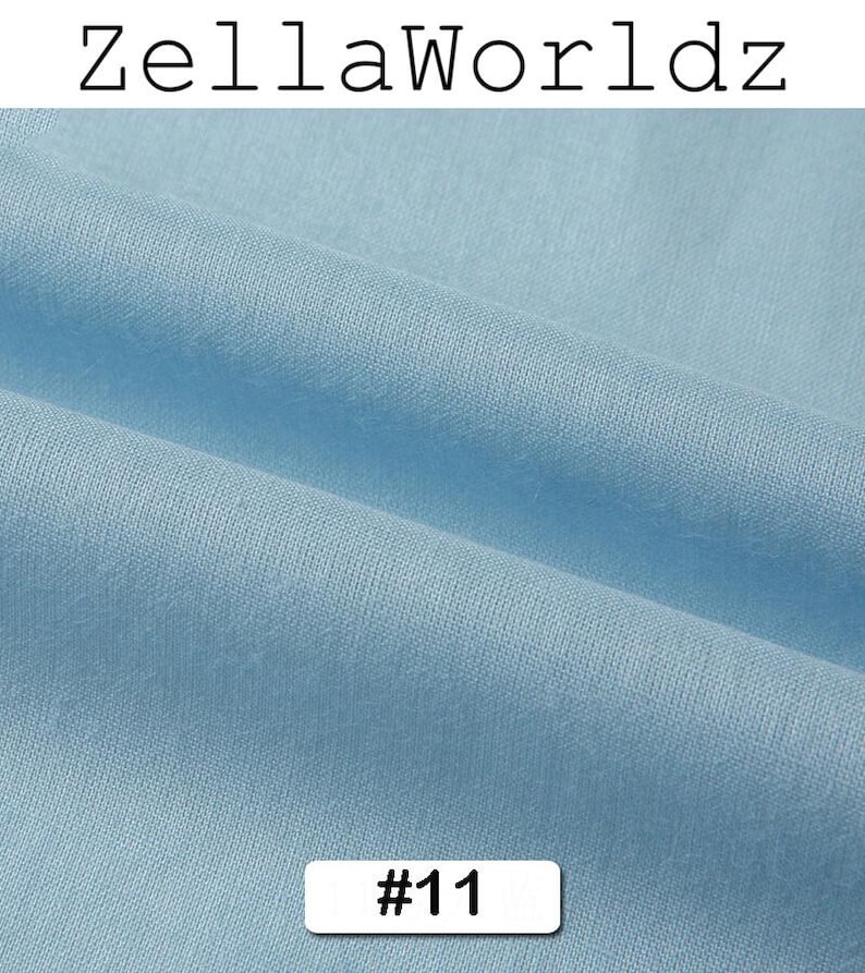 Peut inclure: Gros plan sur un tissu bleu clair avec des plis doux. Le tissu a une texture lisse. Le texte "ZellaWorldz" est en haut et le num&eacute;ro "#11" dans un rectangle blanc en bas.