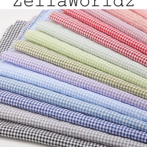 Pode incluir: Uma coleção de tecido xadrez vichy em várias cores, incluindo vermelho, rosa, verde, azul e preto. O tecido é disposto em um padrão em camadas, com o texto "ZellaWorldz" no topo.