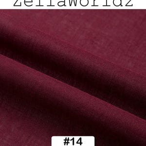 Peut inclure: Gros plan sur un tissu bordeaux fonc&eacute; avec une texture et des plis visibles. Le texte "ZellaWorldz" est en haut et un rectangle blanc avec le num&eacute;ro "#14" est en bas. Le tissu semble &ecirc;tre un textile.