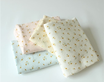 May include: Four pieces of fabric with a small floral pattern. The fabric is in shades of light blue, light yellow, and light pink.