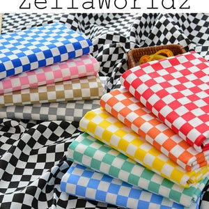 May include: A collection of folded fabric pieces featuring a checkered pattern in various colors including blue, pink, tan, gray, red, orange, yellow, teal, and light blue, all set against a black and white checkered background with the text ZellaWorldz.