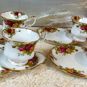 May include: Set of four bone china teacups and saucers with a floral pattern. Each cup and saucer has a matching plate with a scalloped edge.