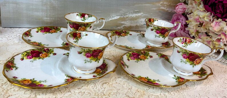 May include: Set of four bone china teacups and saucers with a floral pattern. Each cup and saucer has a matching plate with a scalloped edge.