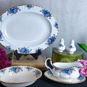 May include: A set of vintage china in the Old Country Roses pattern. The set includes a large oval serving platter, a round bowl, a gravy boat with a matching saucer, and two salt and pepper shakers.
