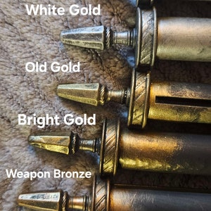 May include: Six metal decorative finials in various finishes, including shining silver, white gold, old gold, bright gold, weapon bronze, and rough iron. The finials are arranged in a row from top to bottom, with the shining silver finial at the top and the rough iron finial at the bottom.