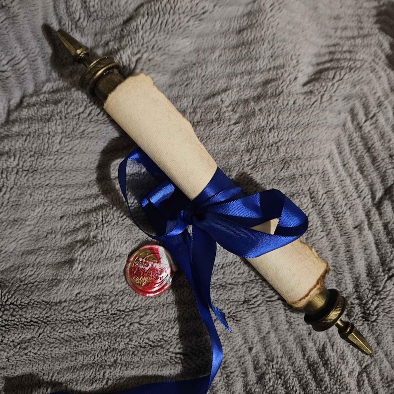 May include: A rolled up scroll tied with a blue ribbon and sealed with a red wax seal. The scroll has a decorative metal end cap.