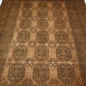 K&ouml;nnte beinhalten: Ein brauner und schwarzer Teppich mit geometrischem Muster. Der Teppich hat ein zentrales Feld mit einem sich wiederholenden Muster aus Achtecken und Quadraten. Der Rand ist ein schmales Band mit geometrischen Mustern.