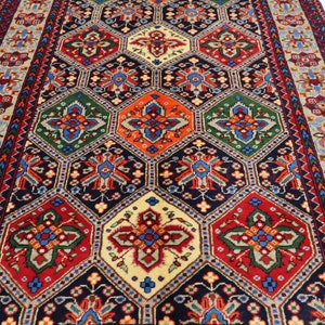 May include: A traditional rug with a geometric pattern in shades of red, blue, green, and cream. The rug has a central medallion and a border with floral motifs.