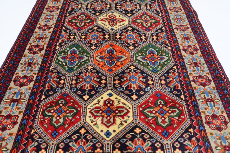 May include: A traditional rug with a geometric pattern in shades of red, blue, green, and cream. The rug has a central medallion and a border with floral motifs.