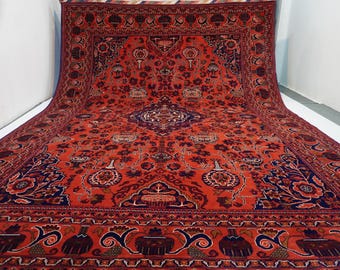 May include: A large, red and blue Persian rug with intricate floral patterns. The rug has a central medallion and a border with a repeating design.