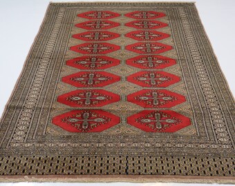 May include: A red and beige rug with a geometric pattern. The rug has a border with a repeating design. The rug is made of wool and is hand-knotted.