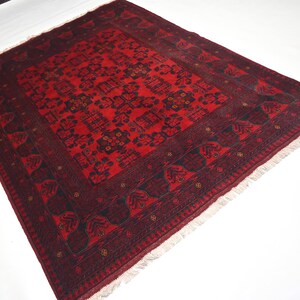 May include: A red and black patterned rug with a fringe border. The rug has a traditional design with intricate details.