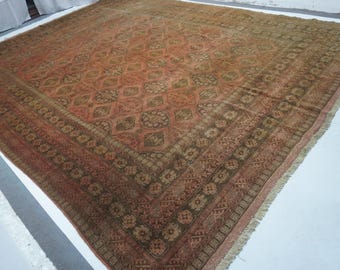 May include: A large square area rug featuring a terracotta and brown colour palette. The central field displays a repeating geometric diamond pattern with floral motifs, framed by a wide border with intricate repeating floral and linear designs.