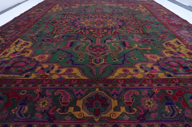 May include: A vintage rug with a colourful geometric pattern. The rug features shades of green, yellow, pink, and purple. The design is intricate and detailed, with a central medallion and repeating motifs.