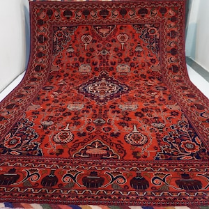 May include: A red and blue Persian rug with a floral pattern. The rug has a central medallion and a border with intricate designs.