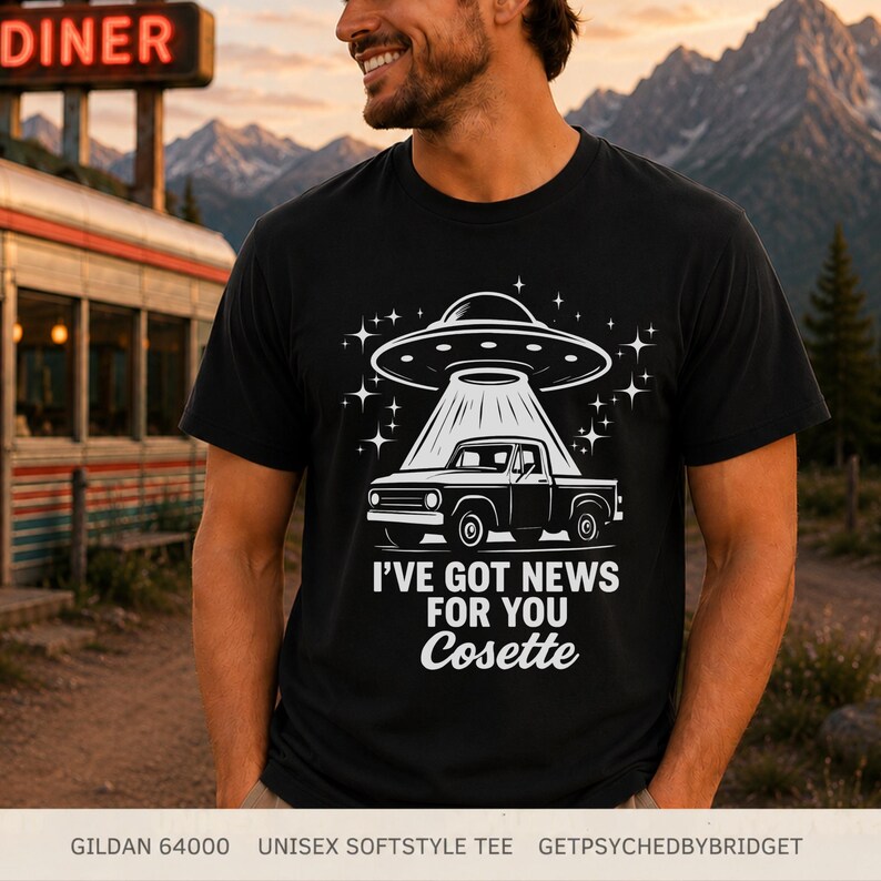 May include: A black short-sleeve t-shirt featuring a white graphic of a pickup truck being abducted by a UFO. The design includes the text I'VE GOT NEWS FOR YOU Cosette. The shirt is a Gildan 64000 unisex softstyle tee with a crew neckline.