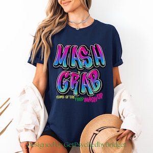 May include: A navy blue t-shirt with a colourful graphic that says "MASH GRAB" and "HOME OF THE FOOD MASH-UP".
