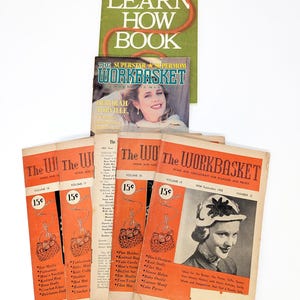 May include: A collection of vintage magazines and a book on a white background. The magazines, titled "The Workbasket," feature orange covers with illustrations and text. A green book, "Learn How Book," is also present, along with a magazine titled "The Superstar Supermom Workbasket."