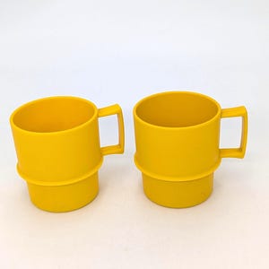 May include: A set of three ceramic mugs with a speckled, matte finish. Each mug features a different color: light blue, cream, and gray. The mugs have a simple, modern design and a comfortable handle.