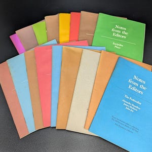 May include: A stack of colorful paperbacks with the title "Notes from the Editors" on the top two books. The books are arranged in a fan shape, with the spines facing out. The books are all different colors, including red, orange, yellow, green, blue, and purple.