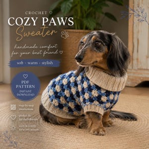 Op de afbeelding: Een teckel draagt een handgemaakte gehaakte trui. De trui heeft een blauw en crèmekleurig geometrisch patroon met een geribbelde kraag. De afbeelding bevat de tekst "COZY PAWS Sweater" en "PDF PATTERN INSTANT DOWNLOAD."