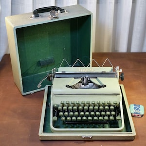 Könnte beinhalten: Ein Set aus drei Keramikbechern mit gesprenkelter, matter Oberfläche. Die Becher sind in Creme-, Hellgrau- und Dunkelgrautönen gehalten. Jeder Becher hat ein schlichtes, minimalistisches Design und einen abgerundeten Henkel. Für Kaffee oder Tee.