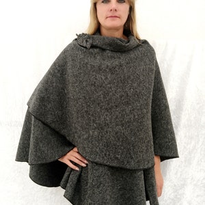 May include: A grey, double-layered poncho with a cowl neck and a ruffled hem.