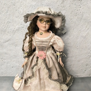 Vintage porcelain doll in Victorian dress, collectible elegant doll in dress with lace and hat with feathers, beautiful doll as a gift