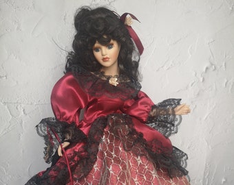 poupée brune en porcelaine vintage aux lèvres charnues, poupée de collection en robe bordeaux et avec masque vénitien, cadeau collector