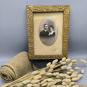 Vintage photo frame early 20th century, antique wooden frame with old photo, openwork gilded frame, vintage wall decoration