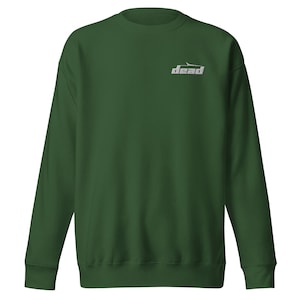 May include: A dark green sweatshirt with the word "dead" printed in silver on the upper chest. The sweatshirt has a crew neck and long sleeves. The fabric appears soft and comfortable.