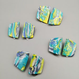 May include: A set of six colourful, abstract patterned earrings. The earrings are made of a lightweight material and have a unique, modern design.