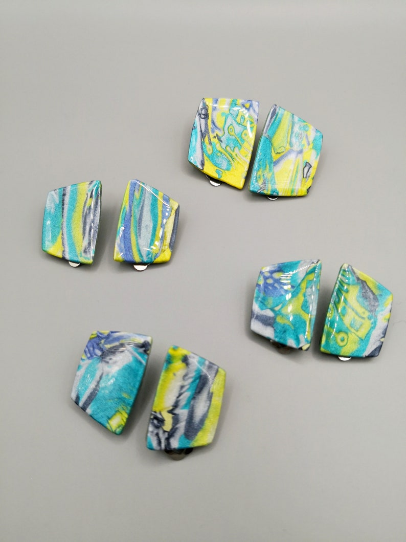 May include: A set of six colourful, abstract patterned earrings. The earrings are made of a lightweight material and have a unique, modern design.