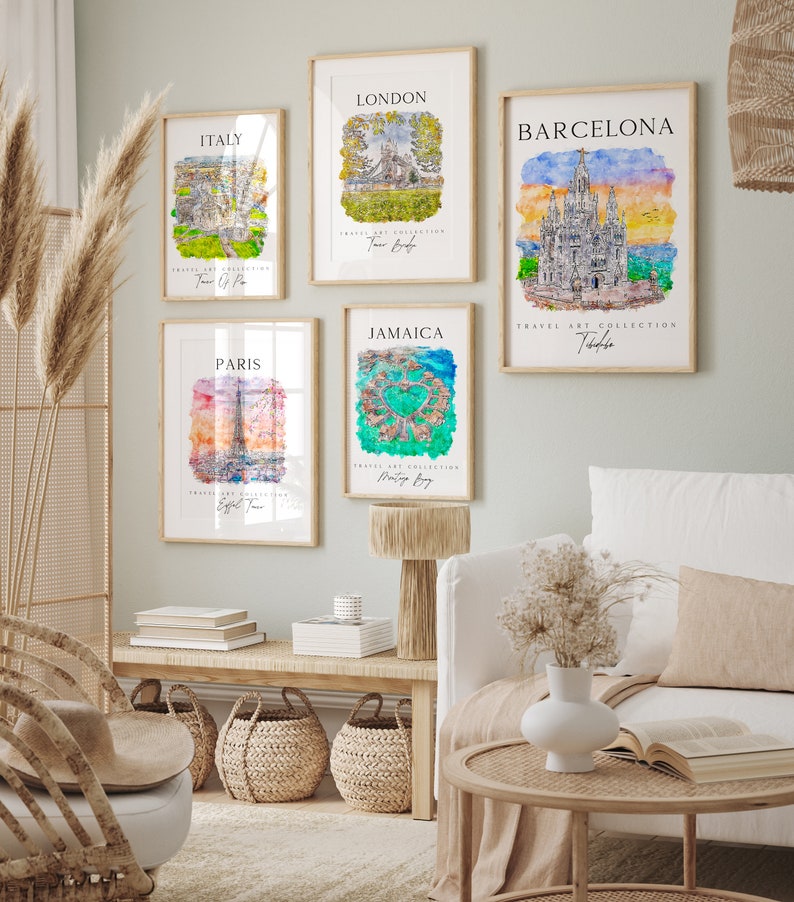 May include: Five watercolor paintings of different cities around the world. Each painting features a landmark building or structure, such as the Eiffel Tower in Paris, Big Ben in London, and the Sagrada Familia in Barcelona. The paintings are framed in light wood and are displayed on a white wall.