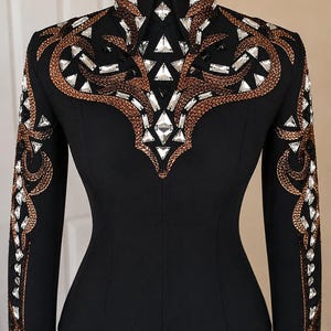 May include: A black long-sleeve shirt featuring a high collar and intricate embellishments. The chest and sleeves are decorated with copper-coloured beadwork and clear, faceted crystals arranged in swirling patterns and geometric shapes.