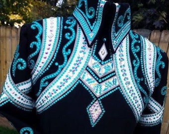 May include: A black long-sleeve shirt featuring intricate turquoise and white patterns with extensive crystal embellishments across the chest, collar, and sleeves. The text BOBBY WESTERN SHOP is printed in white across the lower portion of the shirt.