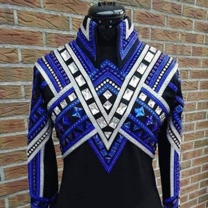 May include: A black long-sleeve shirt featuring a high collar and an intricate V-shaped chest panel adorned with blue and silver geometric patterns, rows of clear crystals, and faceted blue stones that extend down the sleeves and neckline.