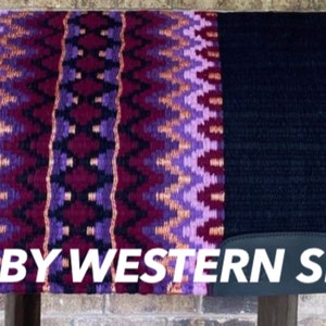 May include: A purple, pink and orange patterned saddle pad with a black border. The saddle pad has a black leather flap with the text "BOBBY WESTERN SHOP" on it.