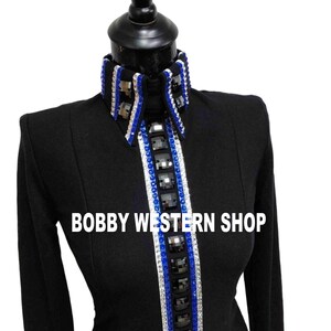 Könnte beinhalten: Ein schwarzes Langarmshirt mit hohem Kragen und einer vertikalen Frontpartie, die mit Reihen aus blauen und klaren Kristallen sowie großen quadratischen schwarzen Steinen verziert ist. Der Text BOBBY WESTERN SHOP ist in Weiß aufgedruckt.