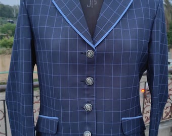 May include: A navy blue blazer featuring a white grid pattern, light blue piping along the lapels and pocket flaps, and four silver-toned buttons down the front. The text BOBBY WESTERN SHOP is printed in white at the bottom of the image.