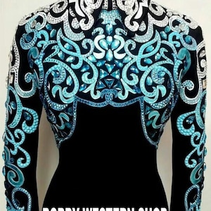 Könnte beinhalten: Ein schwarzes Langarmshirt mit einem aufwendigen Kragen- und Brustdesign, das mit türkisfarbenen und silbernen Kristallen in Wirbelmustern verziert ist. Der Text BOBBY WESTERN SHOP ist unten auf dem Kleidungsstück in Weiß aufgedruckt.