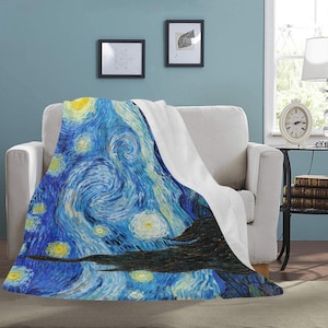 May include: A soft, white fleece throw blanket with a printed design of Vincent van Gogh's "Starry Night" painting. The blanket features swirling blue and yellow hues with a dark silhouette of a tree in the foreground.