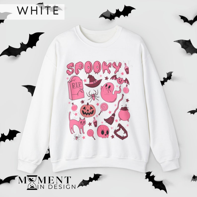 pink aesthetic halloween sweatshirt for women. contains pink graphics of ghosts, pumpkins, cats, potions, and candy.